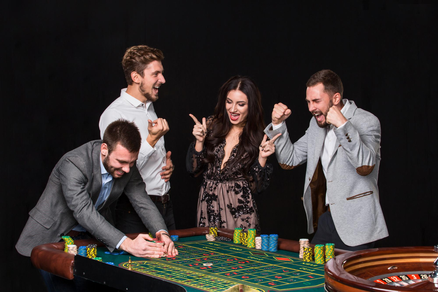 group-young-people-roulette-table-black-background-young-man-rejoices-victory